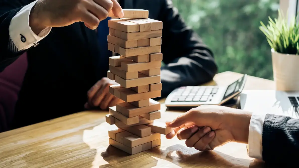 Attorney pulling a Jenga block representing how a mechanics lien can be challenged and defeated