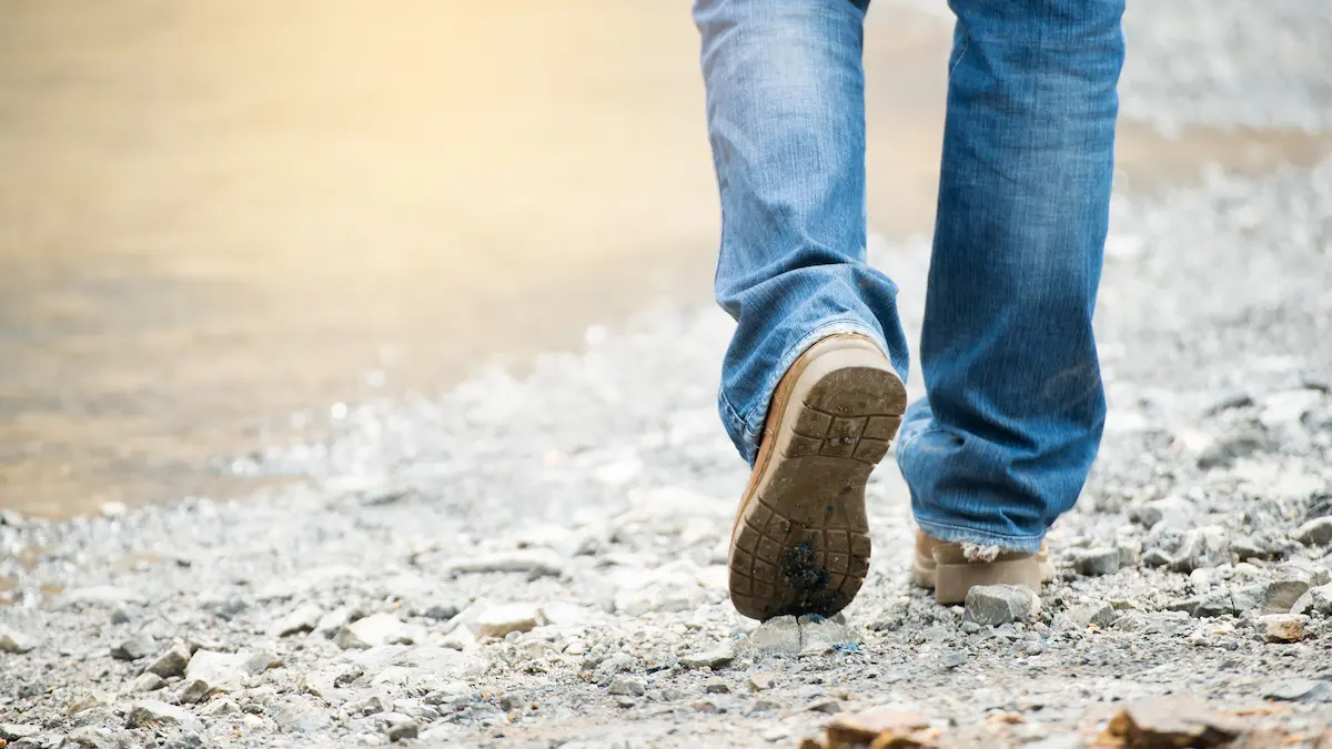 Contractor in work boots walking away from a construction job site