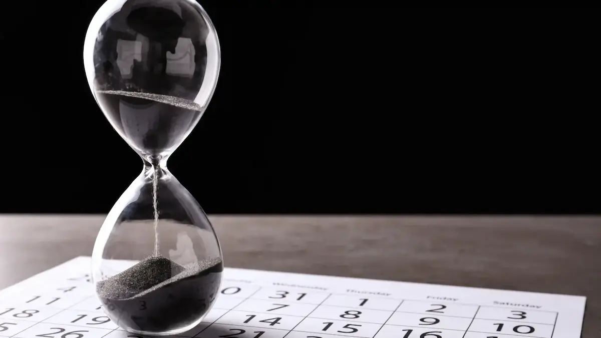 Hourglass on a calendar representing mechanics lien deadlines and the last date of work