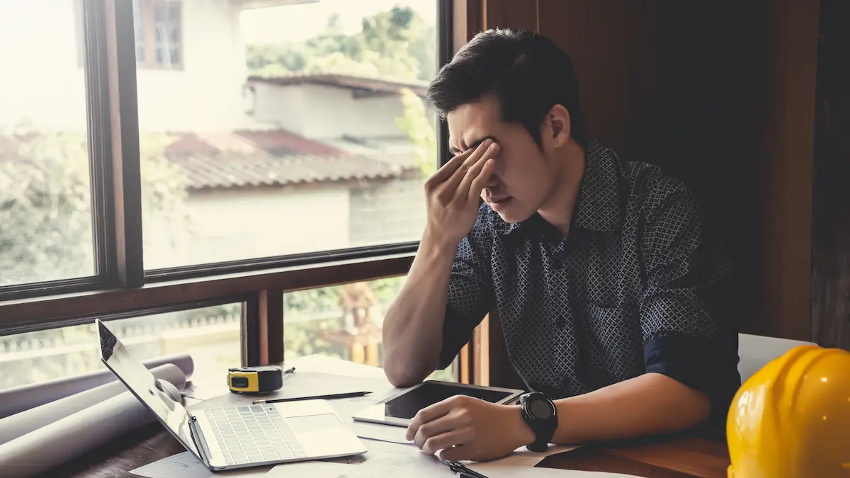 Frustrated subcontractor reviewing unpaid invoices and contract documents at a Chicago commercial construction project